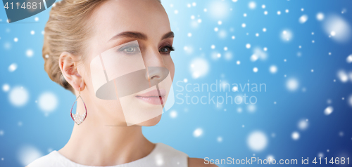 Image of close up of woman with pearl earring over snow