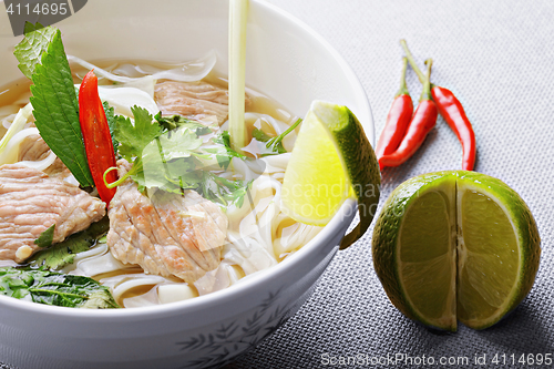 Image of Pho bo soup with lime and chili closeup