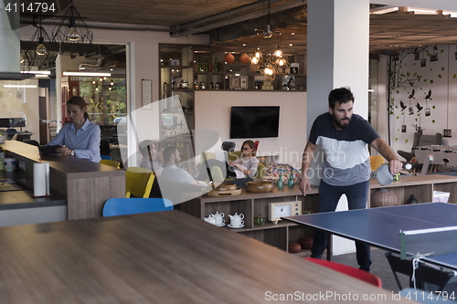 Image of playing ping pong tennis at creative office space