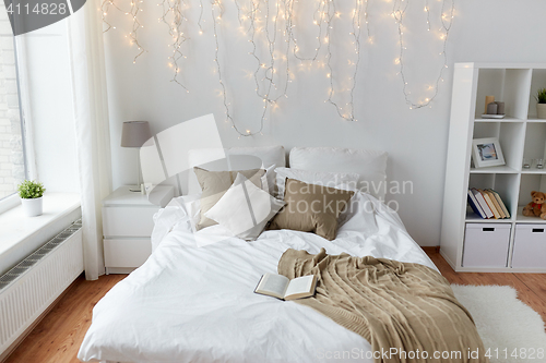 Image of bedroom with bed and christmas garland at home
