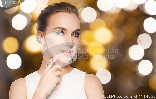 Image of woman in white with diamond ring and earring