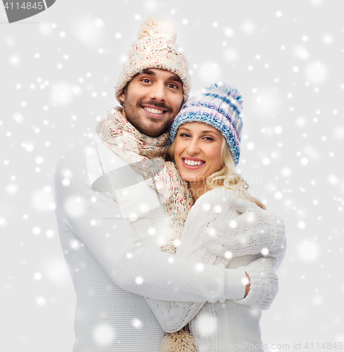 Image of smiling couple in winter clothes hugging