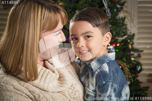 Image of Mother and Mixed Race Son Hug Near Christmas Tree