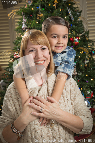 Image of Mother and Mixed Race Son Hug Near Christmas Tree