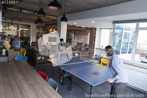 Image of playing ping pong tennis at creative office space