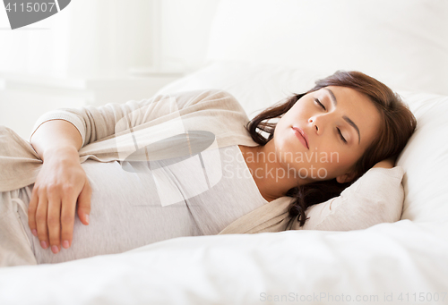 Image of happy pregnant woman sleeping in bed at home