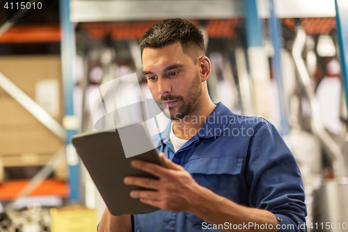 Image of auto mechanic or smith with tablet pc at workshop