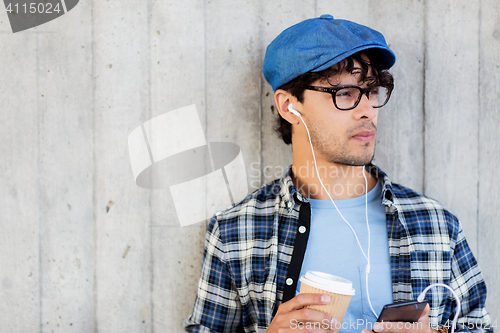 Image of man with earphones and smartphone drinking coffee