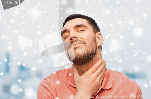 Image of unhappy man suffering from throat pain over snow