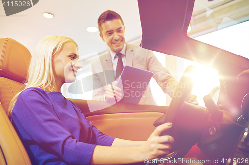 Image of happy woman with car dealer in auto show or salon