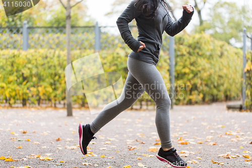 Image of close up of young woman running in autumn park