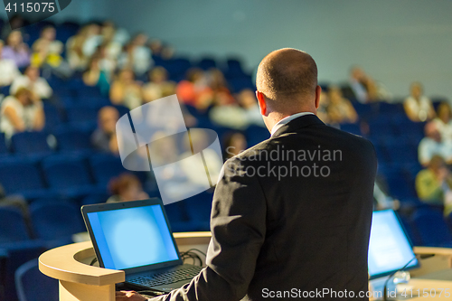 Image of Public speaker giving talk at business event.