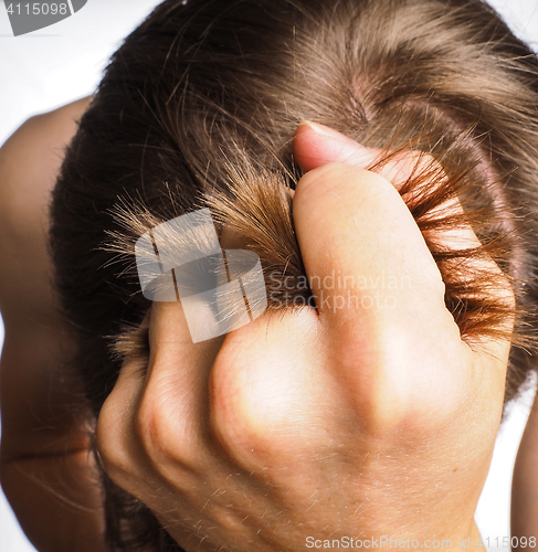 Image of Closeup of hand pulling hair from head of a male person