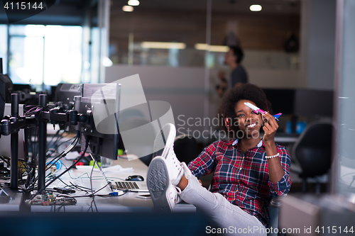 Image of young woman at her office workplace playing with plane toy