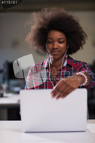 Image of black woman in modern office at her workplace speeking on phone 