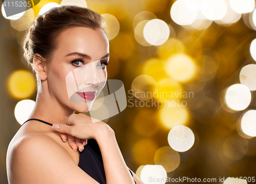 Image of beautiful woman in black over dark background