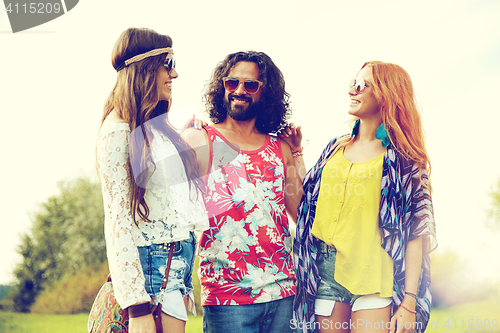 Image of smiling young hippie friends talking outdoors