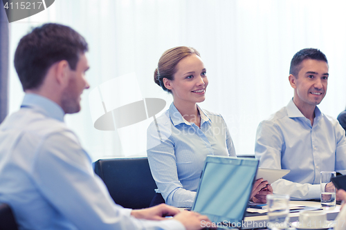 Image of smiling business people with tablet pc in office