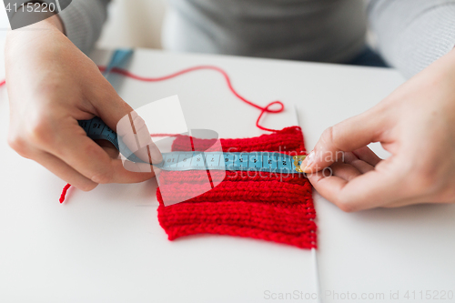 Image of woman with knitting on needle and measuring tape