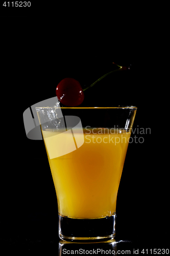 Image of Cherry dropping into orange drink