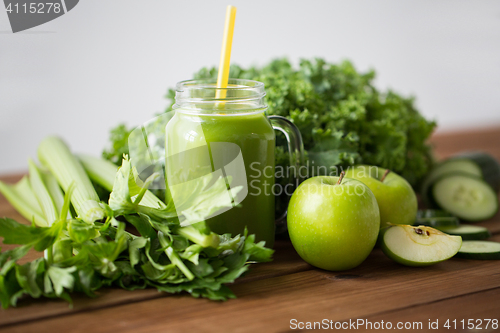 Image of close up of jug with green juice and vegetables