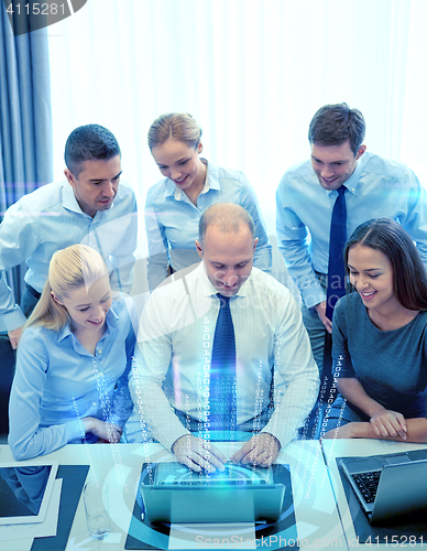 Image of smiling business people with laptop in office