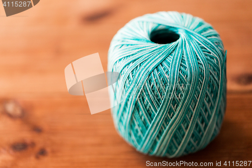 Image of ball of turquoise cotton yarn on wood