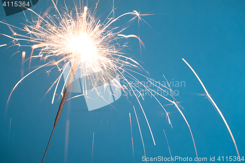 Image of Christmas sparkler on blue background