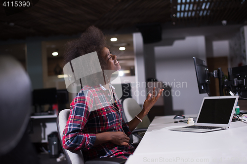 Image of woman at her workplace in startup business office listening musi