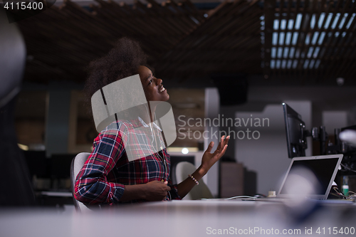 Image of woman at her workplace in startup business office listening musi