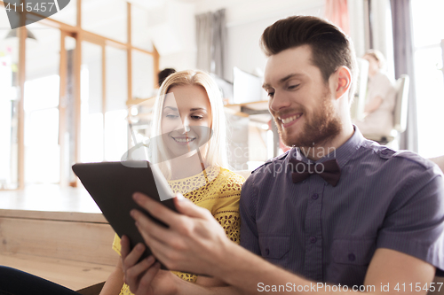 Image of happy creative team with tablet pc in office