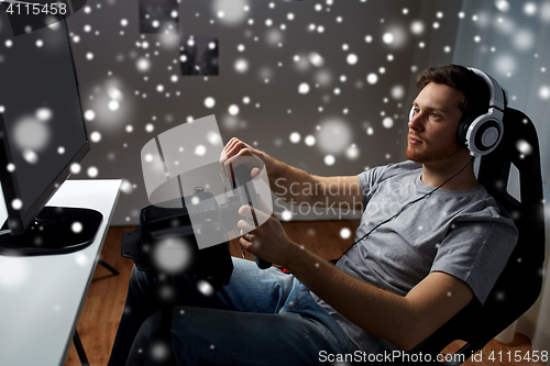 Image of man playing car racing video game at home