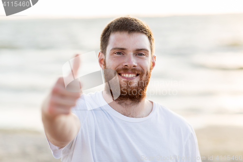 Image of happy smiling young man on beach