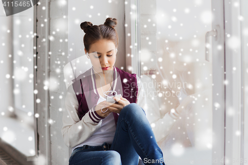 Image of teenage girl with smartphone and earphones