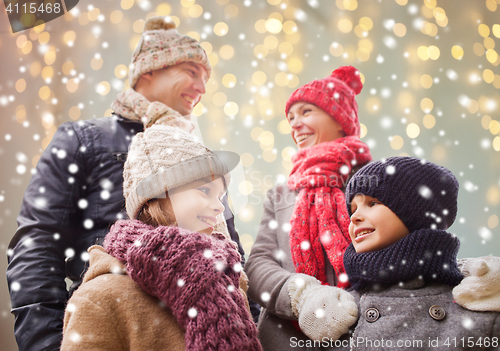 Image of happy family over christmas lights and snow