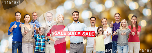 Image of happy people with sale sign showing thumbs up