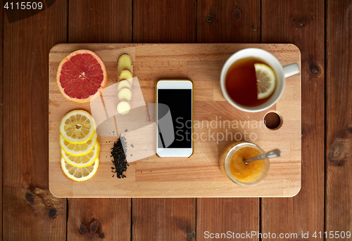 Image of smartphone with cup of lemon tea, honey and ginger