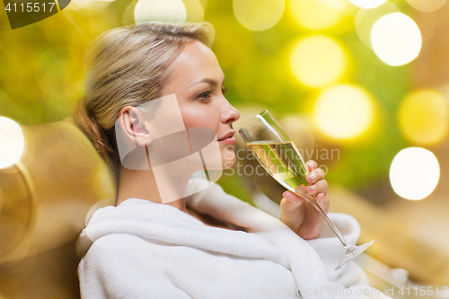 Image of beautiful young woman drinking champagne at spa