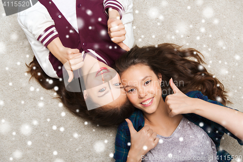 Image of smiling teenage girls on floor showing thumbs up