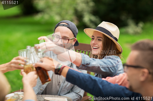 Image of happy friends clinking glasses at summer garden