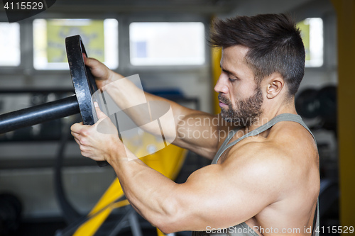 Image of male bodybuilder preparing the weight