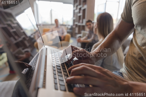 Image of close up of male hands while working on laptop