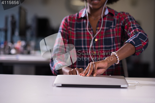 Image of black woman in modern office at her workplace speeking on phone 