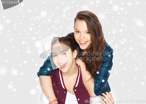 Image of happy smiling teenage girls hugging over snow