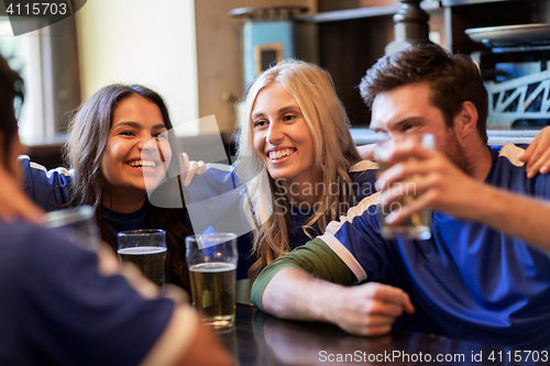 Image of football fans or friends with beer at sport bar