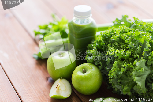 Image of close up of bottle with green juice and vegetables