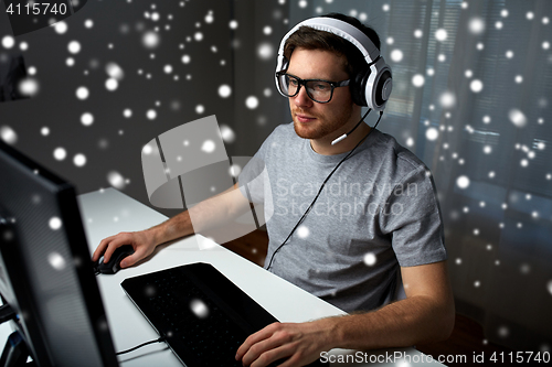 Image of man in headset playing computer video game at home