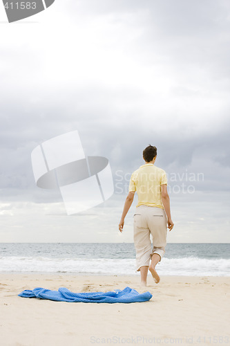 Image of Woman walking on beach
