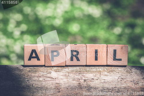 Image of April spring sign in a green garden