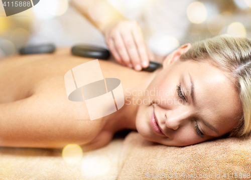 Image of close up of woman having hot stone massage in spa